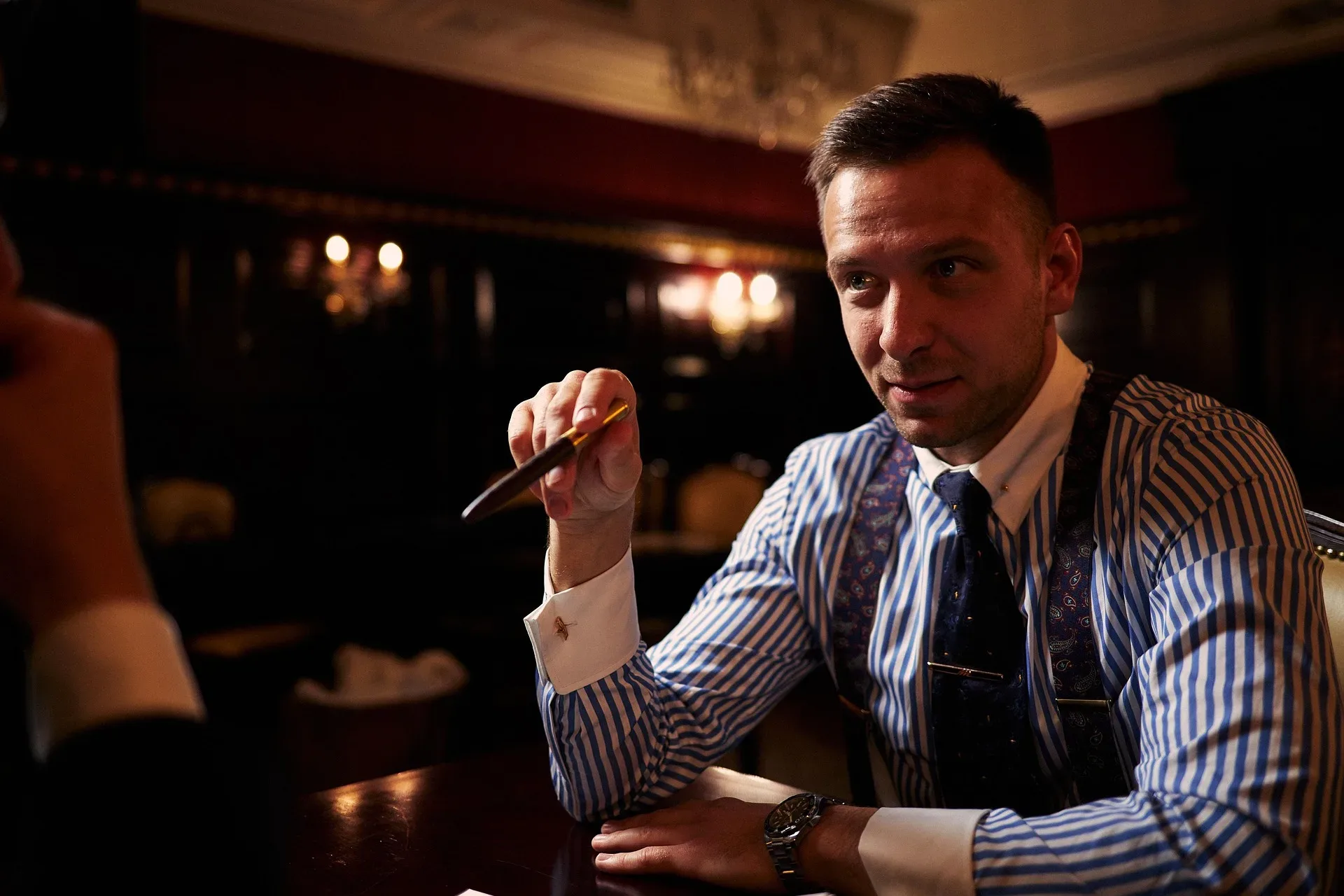 A pen being forced to sign on a dotted line while the author looks away.